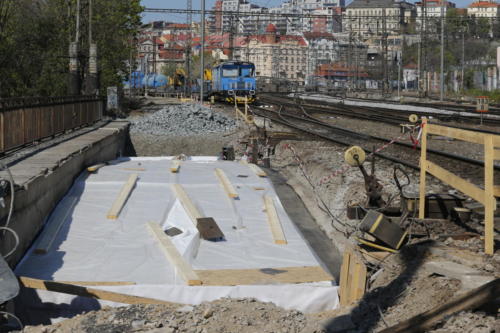Most přes potok Botič po položení izolace spolu s pracovním vlakem stavby v pozadí.